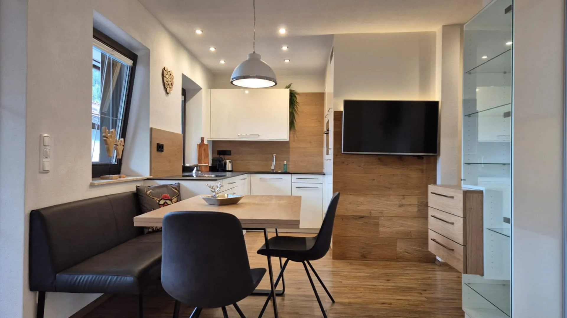modernes Esszimmer mit einem Tisch und Stühlen, Holzflächen und Fernseher