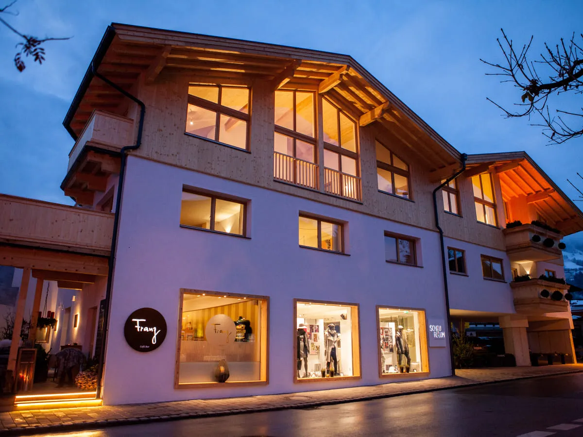 abends beleuchtetes Gebäude von Franz mit großen Fenstern und Holzverkleidung
