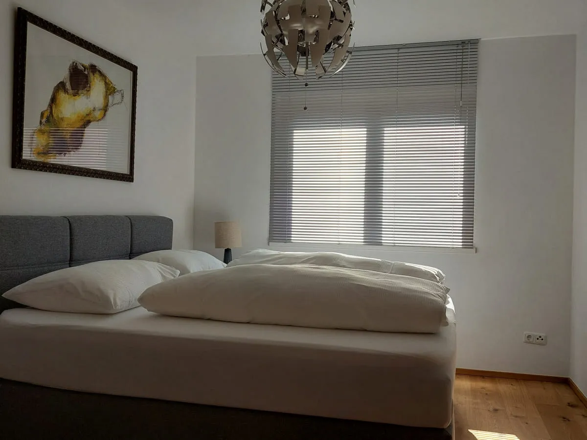 Schlafzimmer mit einem Bett, einem Nachttisch und einem Kunstwerk an der Wand.